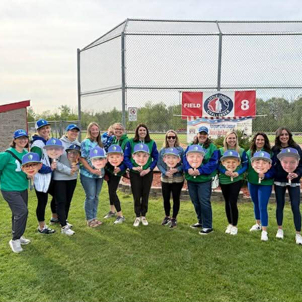 Little League Tournament with a group of mom's holding their children's big head cutouts during Memorial Day weekend.