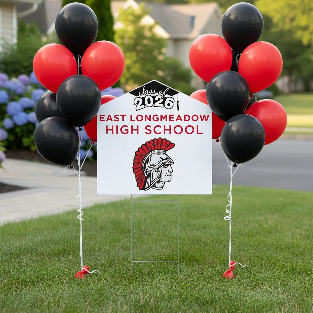 Graduation-themed sign with balloons for East Longmeadow High School Class of 2026 on a grassy lawn.
