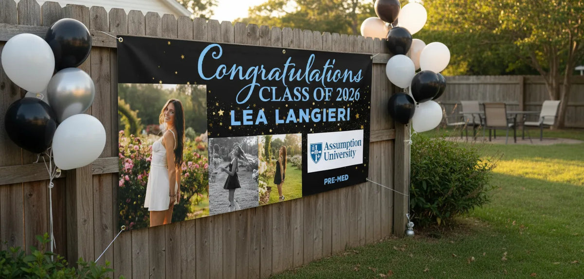 A personalized Class of 2026 graduation photo banner featuring 3 photos, and college branding with student major, on a black background hanging on a fence at an outdoor party with balloons.